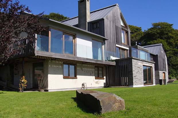 Blue sky and green grass surrounding eco friendly house